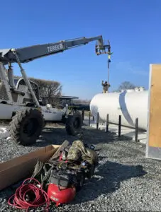 A crane is lifting a tank from the ground.