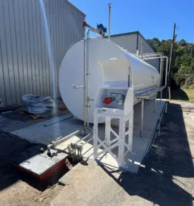 A white tank sitting on top of concrete.