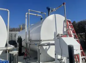 A white tank sitting on top of a cement floor.