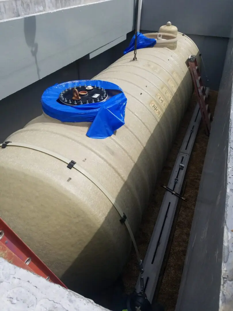 A blue clock sitting on top of a large tank.