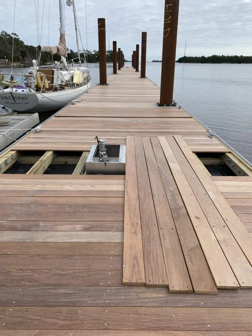 A dock with wooden planks and a boat in the water.