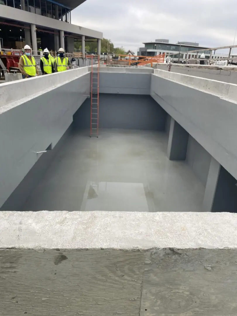 A concrete slab with cement on it and people standing around.