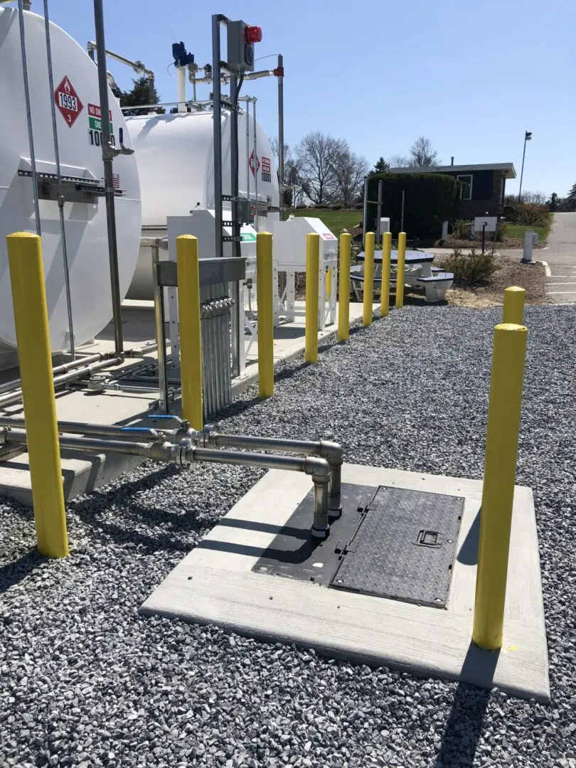 A gas station with yellow posts and pipes.