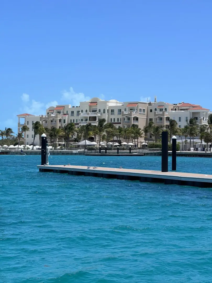 A dock with a view of the ocean and a resort.