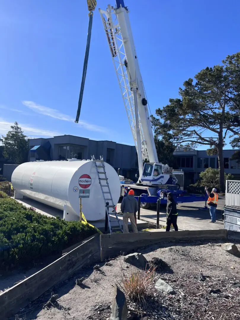 A crane is lifting a tank from the ground.